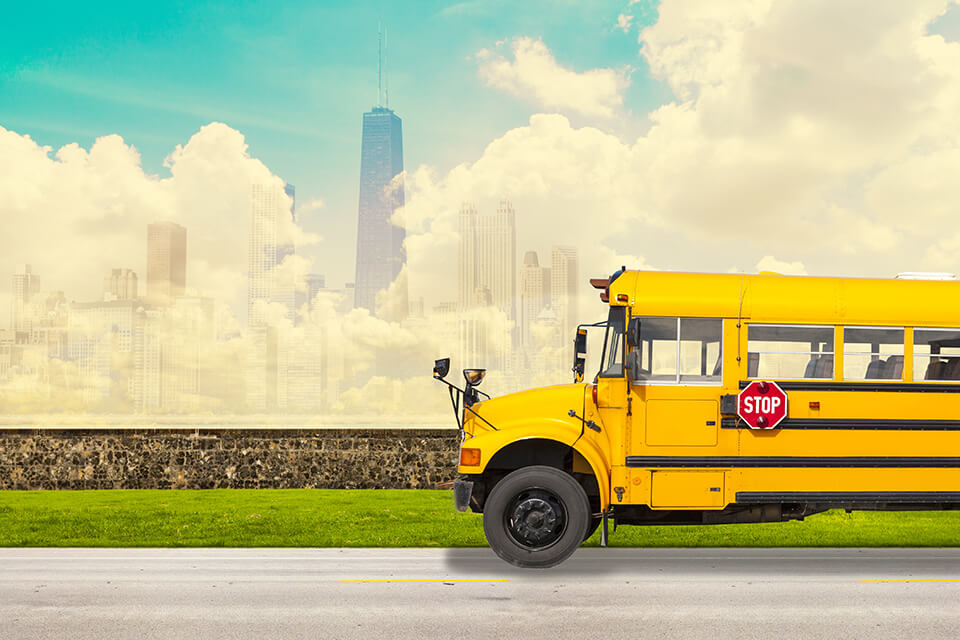 A school bus, clouds, and buildings behind it