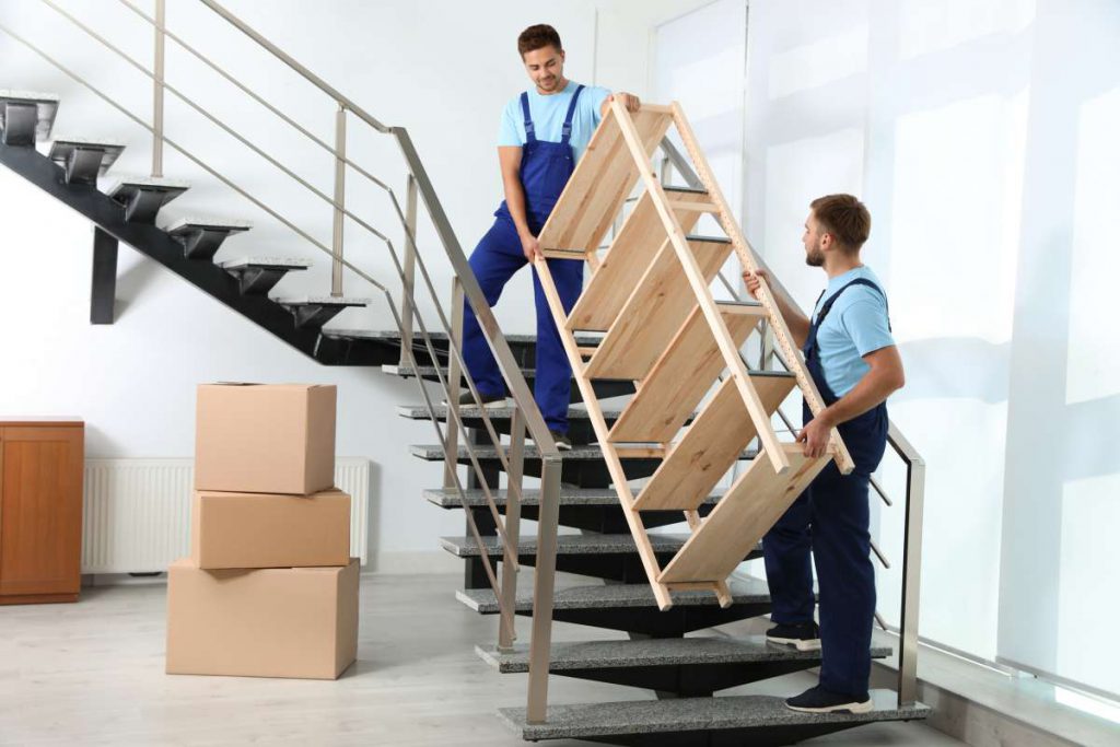 Professional movers in Chicago carrying a shelf down the stairs