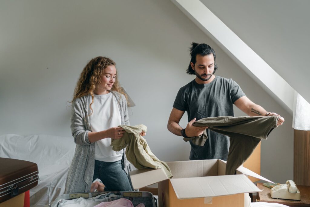 Man and a woman packing clothes in boxes